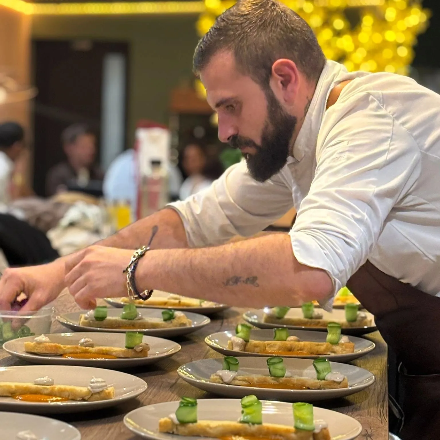 Le Chef dresse les assiettes devant les invités