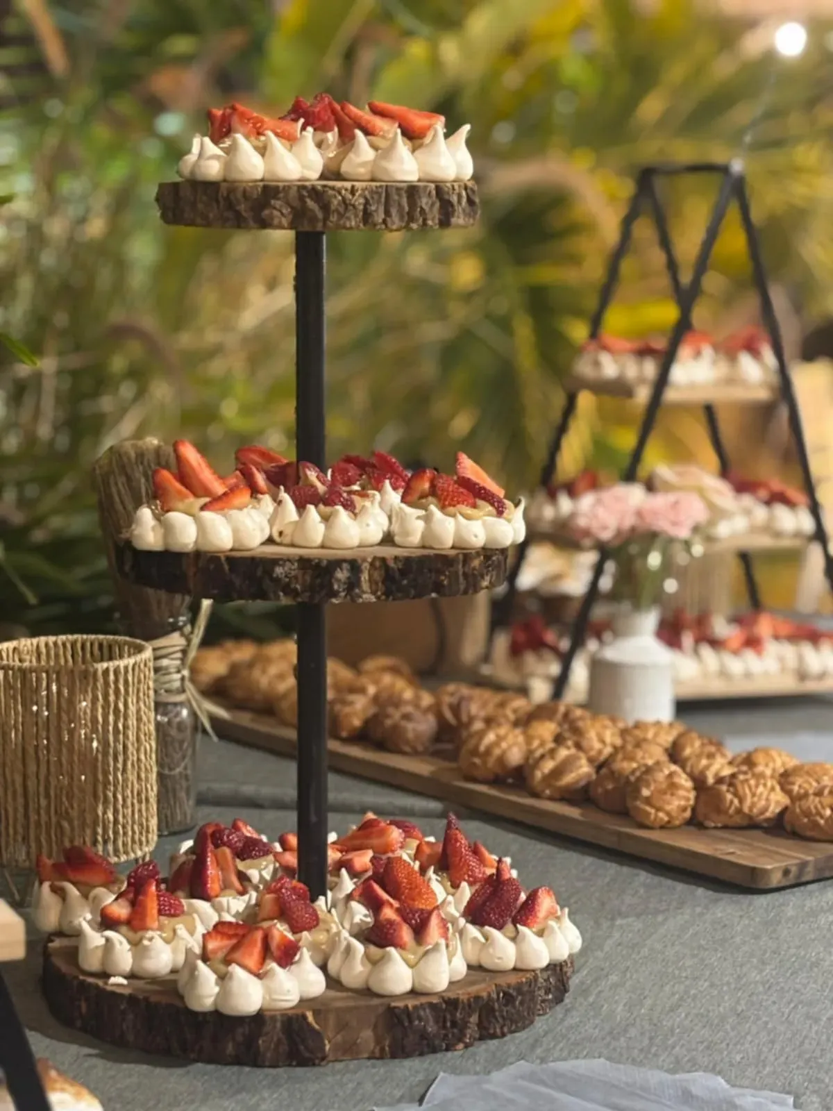 Buffet de desserts de mariage avec pavlovas aux fraises sur présentoirs en bois